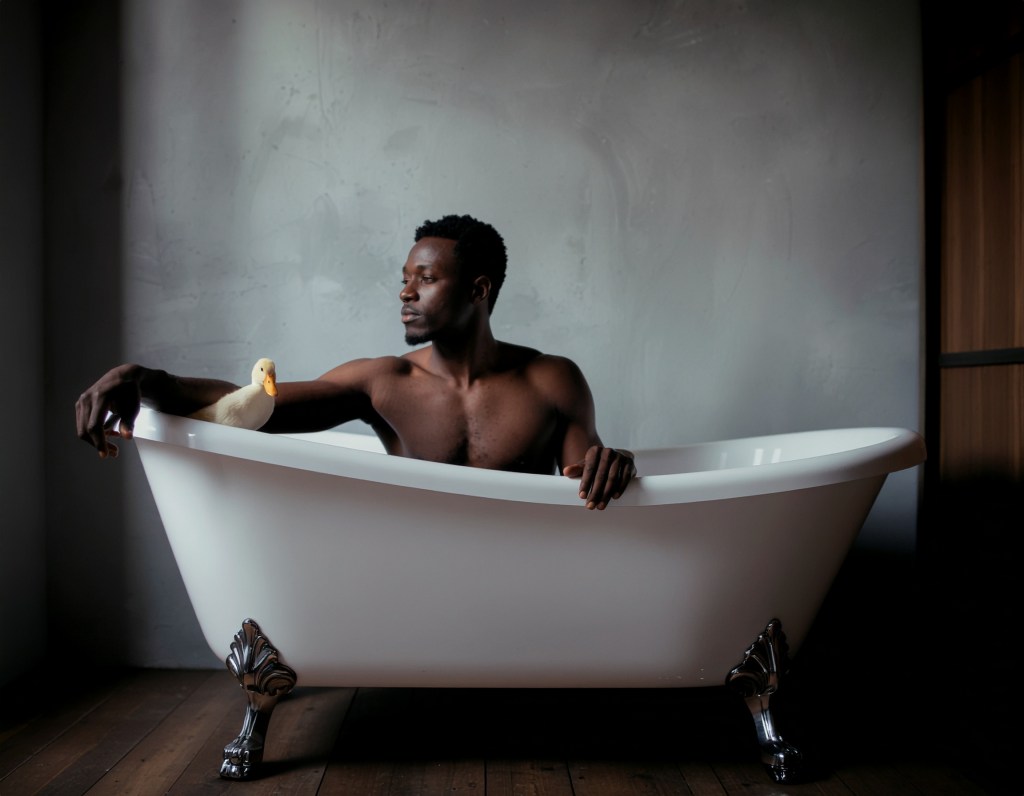 KI: Mann mit Ente in der Badewanne